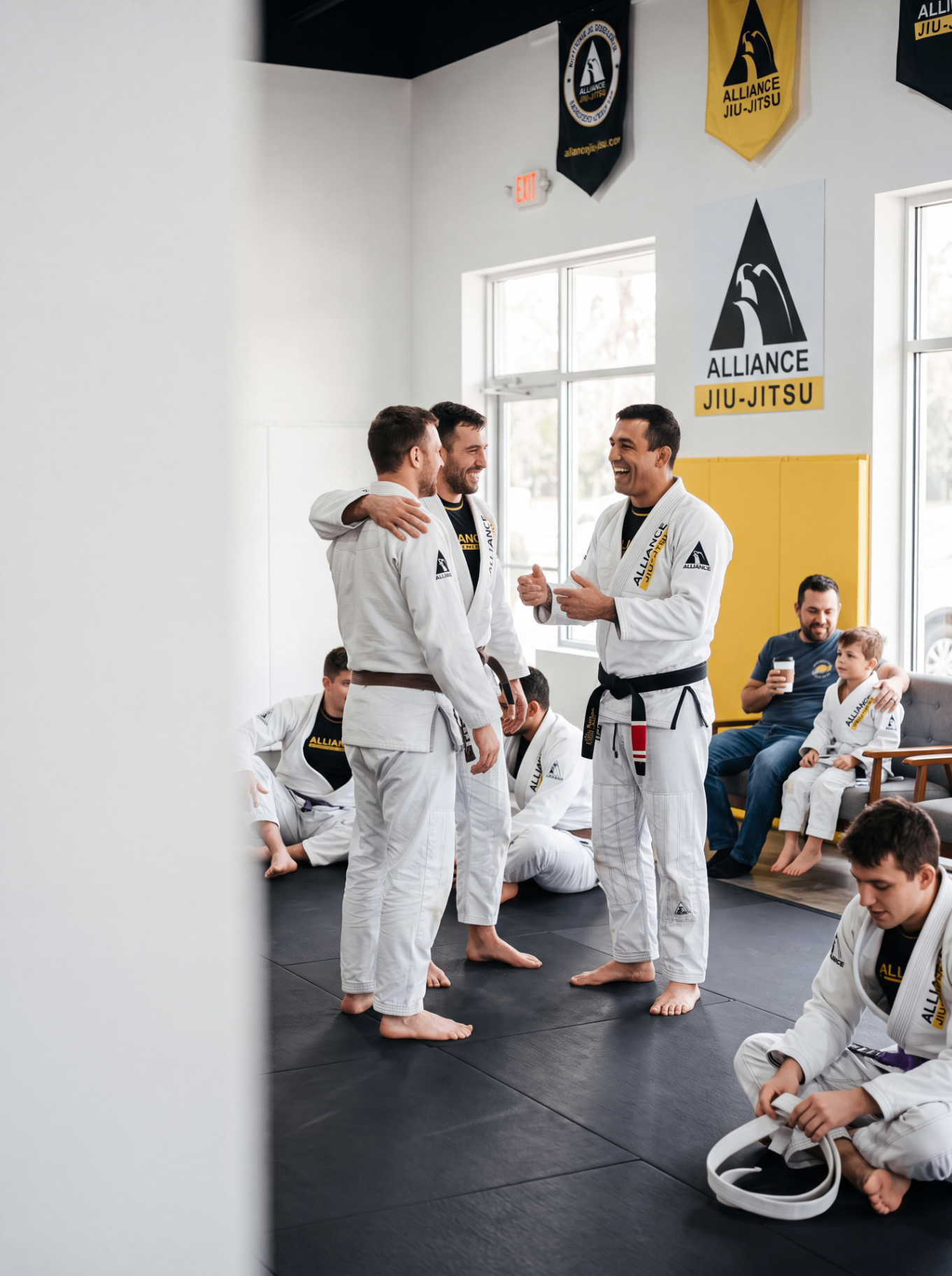 Alliance students and professor sharing a moment on the mats